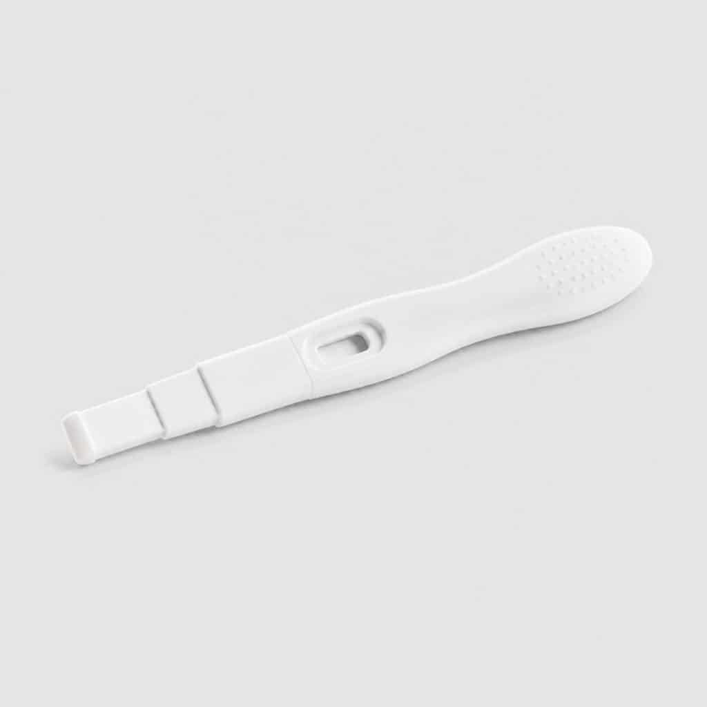Autotest de grossesse ultra-sensible posé sur fond neutre clair