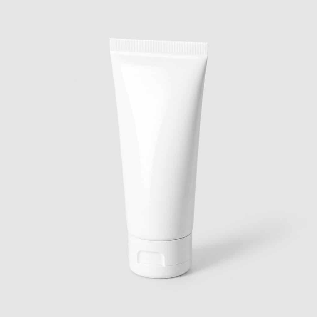 Tube de dentifrice blancheur posé sur fond neutre
